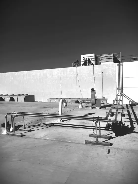 Stainless steel rooftop process piping mounted on custom steel pipe supports by Wetzel Welding