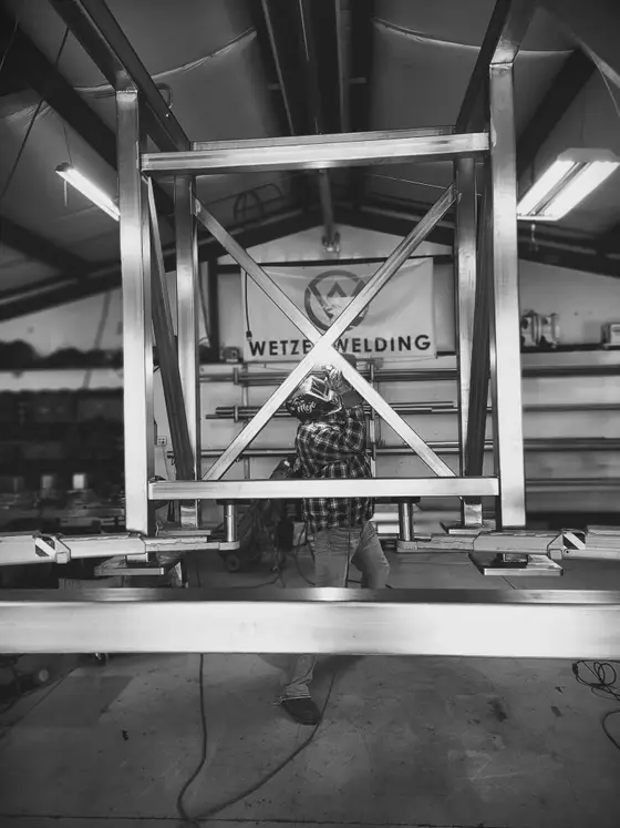 Custom X-braced stainless steel structural frame under fabrication at the Wetzel Welding shop