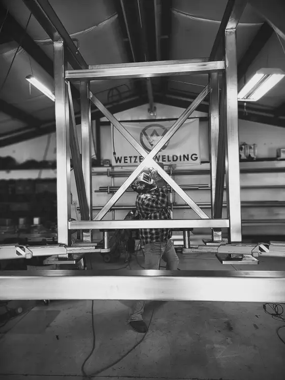 Custom X-braced stainless steel structural frame under fabrication at the Wetzel Welding shop