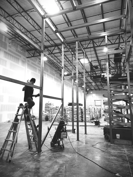 Wetzel Welding building a tall structural steel mezzanine frame inside a large warehouse
